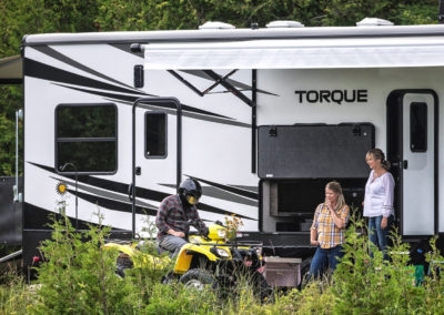 Heartland Torque Toy Hauler with people in front