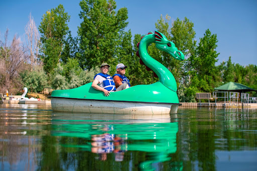 couple in dragon paddle boat on lake